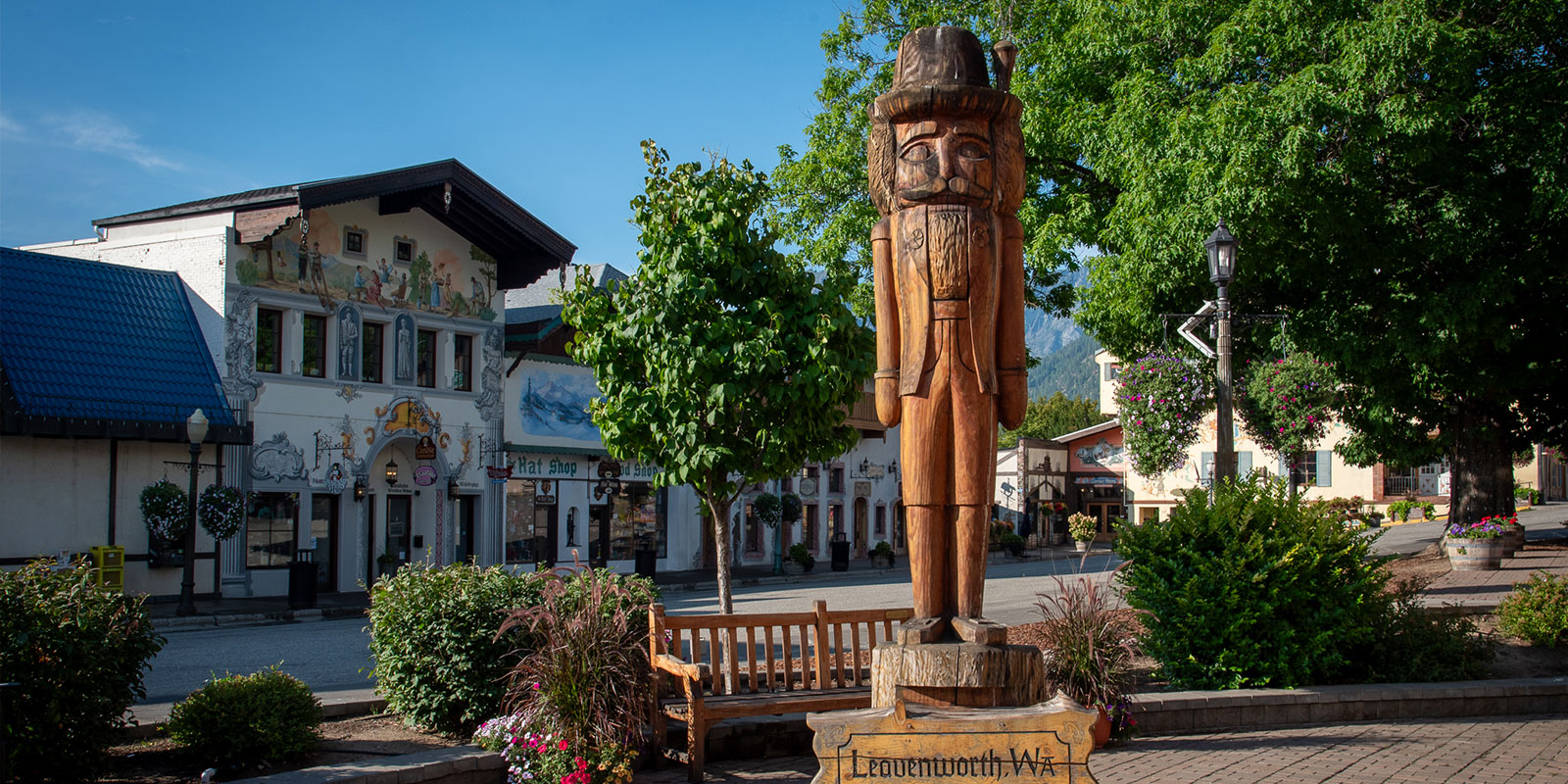 A large wooden statue of a nutcracker stands atop a sign that says: Leavenworth, Washington, The Bavarian Village